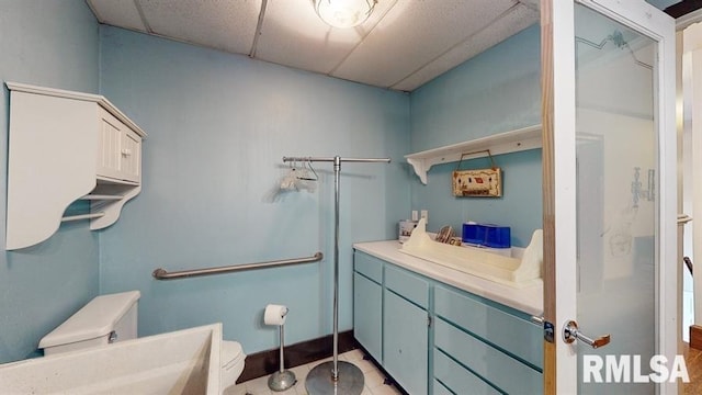 bathroom featuring a paneled ceiling and toilet