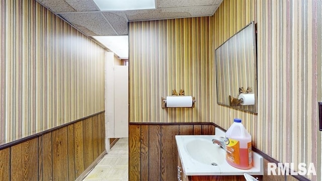 bathroom featuring vanity and a drop ceiling