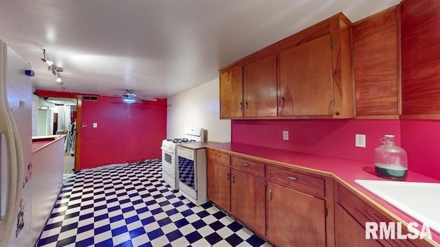 kitchen featuring sink, rail lighting, and white appliances