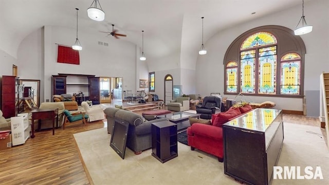 living room featuring high vaulted ceiling, plenty of natural light, light hardwood / wood-style floors, and ceiling fan