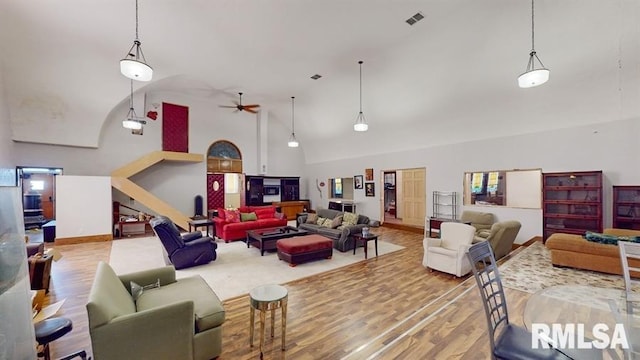 living room with ceiling fan, wood-type flooring, and high vaulted ceiling