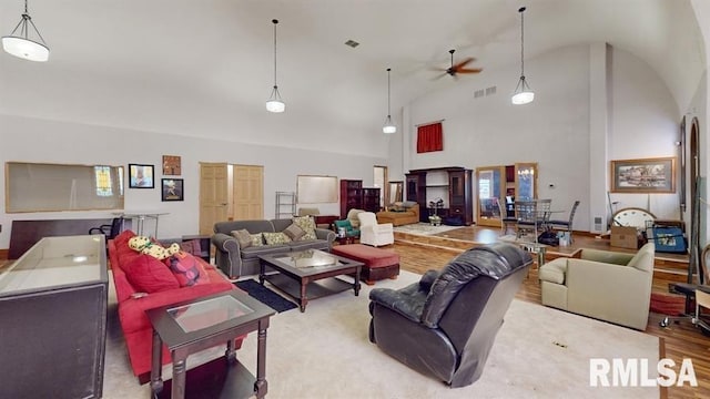 living room with ceiling fan, high vaulted ceiling, and light hardwood / wood-style floors