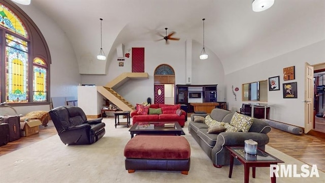 living room with hardwood / wood-style flooring, high vaulted ceiling, and ceiling fan