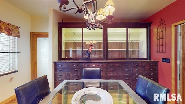 dining space with hardwood / wood-style flooring and an inviting chandelier