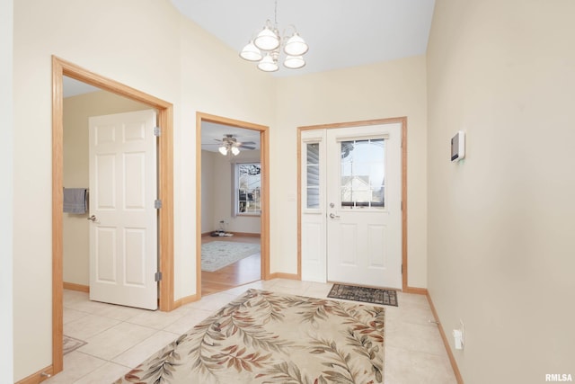 tiled foyer with ceiling fan with notable chandelier