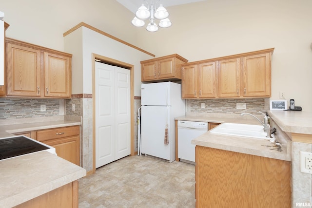 kitchen with decorative backsplash, white appliances, sink, a chandelier, and hanging light fixtures