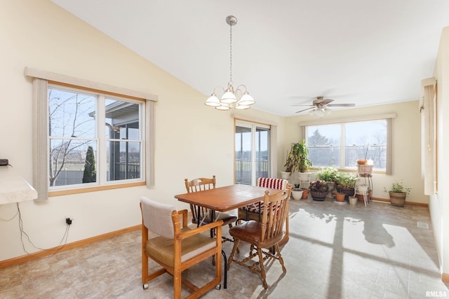 dining room featuring ceiling fan with notable chandelier and lofted ceiling