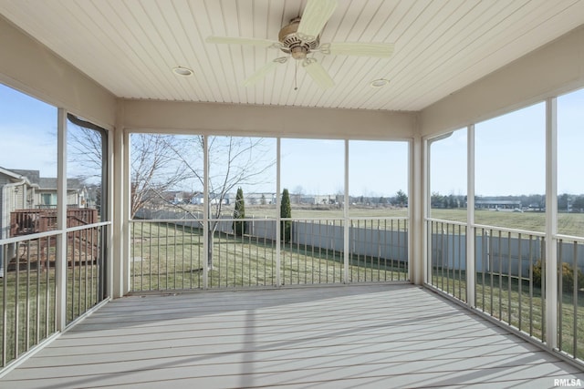 unfurnished sunroom with ceiling fan