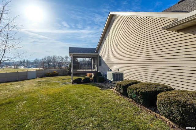 view of property exterior with a sunroom, a yard, and central AC unit