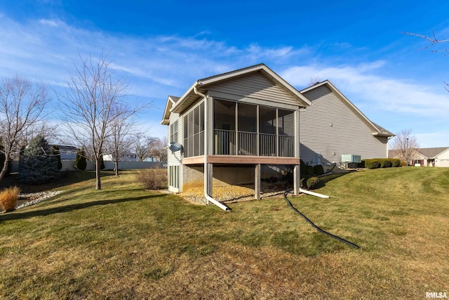 rear view of property with a sunroom and a yard