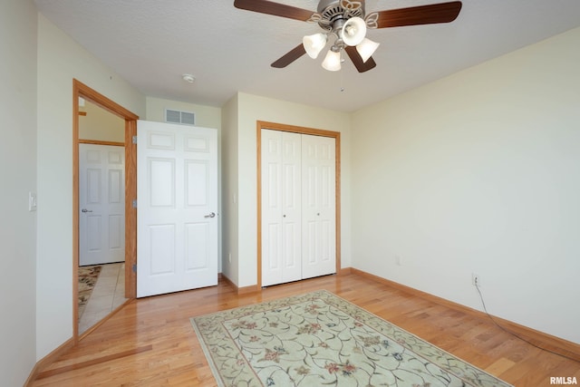 bedroom featuring ceiling fan, light hardwood / wood-style floors, and a closet