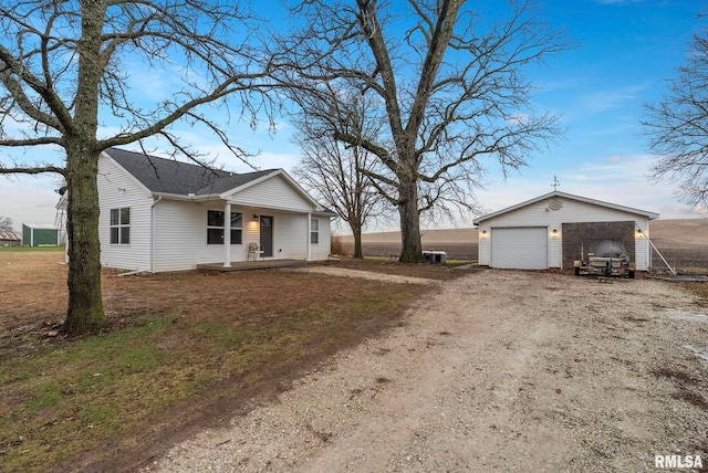 view of front of property featuring covered porch, a garage, and an outdoor structure