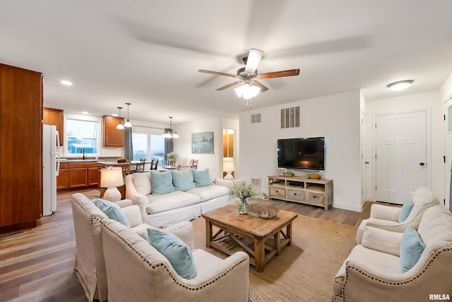 living room with light wood-type flooring and ceiling fan