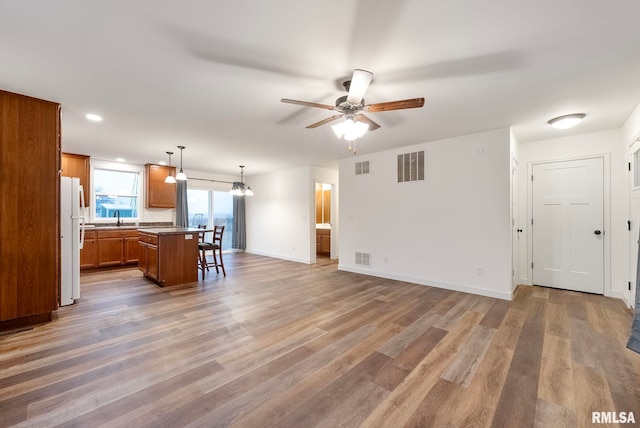 unfurnished living room featuring ceiling fan and wood-type flooring