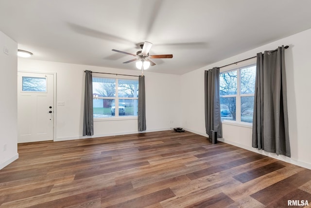 spare room featuring ceiling fan, plenty of natural light, and dark hardwood / wood-style floors