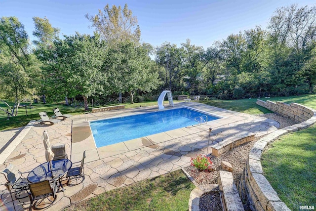 view of pool with a yard, a patio, and a water slide