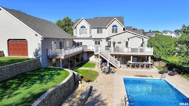 rear view of property with a swimming pool side deck, an outdoor bar, a patio area, and a lawn