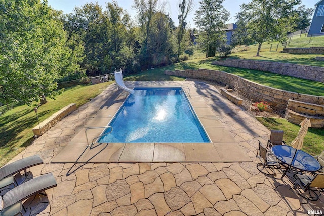 view of swimming pool featuring a patio area, a yard, and a water slide