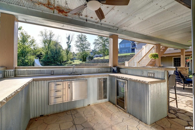 view of patio / terrace with an outdoor kitchen, wine cooler, ceiling fan, and a wet bar