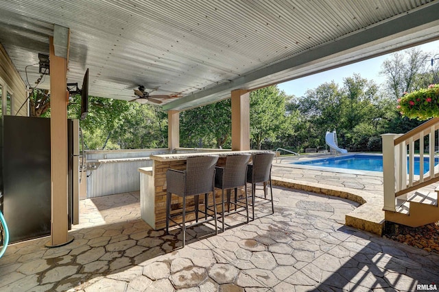 view of patio with ceiling fan and exterior bar