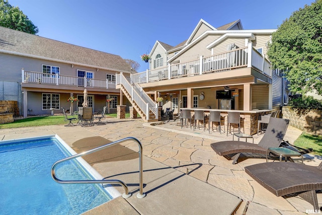 rear view of property with a patio area and a bar