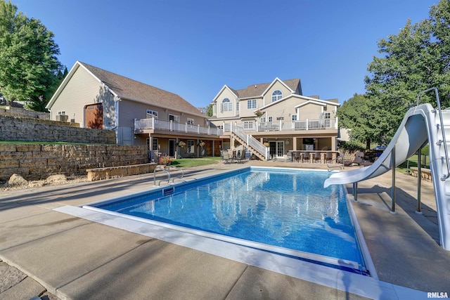 view of swimming pool with an outdoor bar, a patio, and a water slide