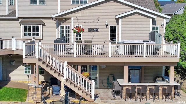 rear view of house with exterior bar, a deck, and a patio area