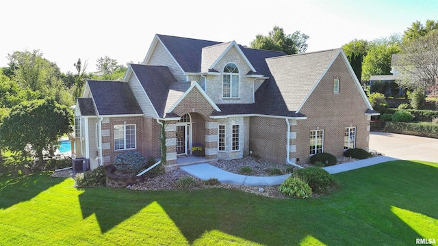 view of front of house featuring cooling unit and a front yard