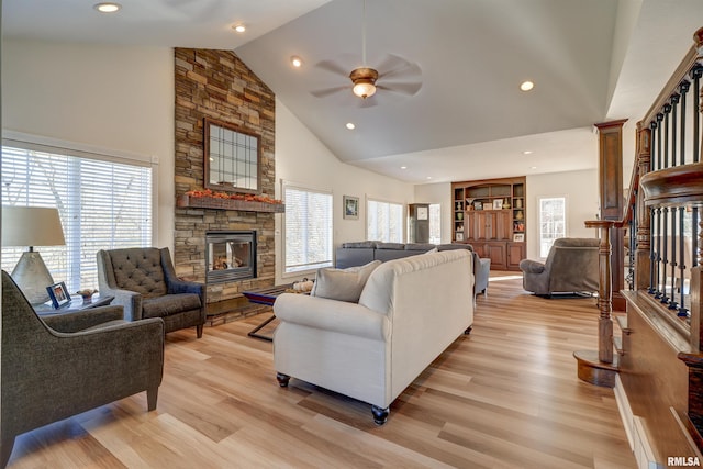 living room with ceiling fan, a fireplace, high vaulted ceiling, and light hardwood / wood-style floors