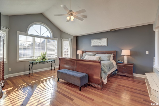 bedroom featuring ceiling fan, light hardwood / wood-style floors, ornate columns, and lofted ceiling