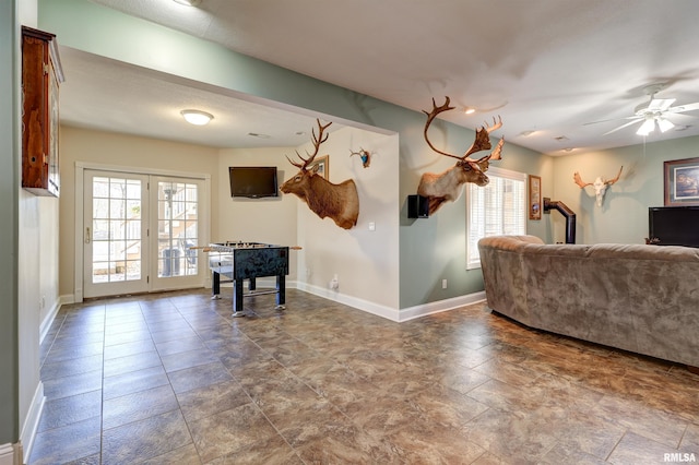 living room with ceiling fan, a healthy amount of sunlight, and french doors