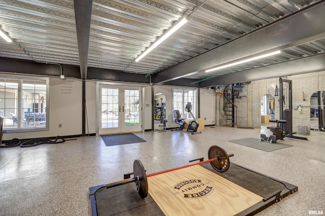 exercise room featuring brick wall and french doors