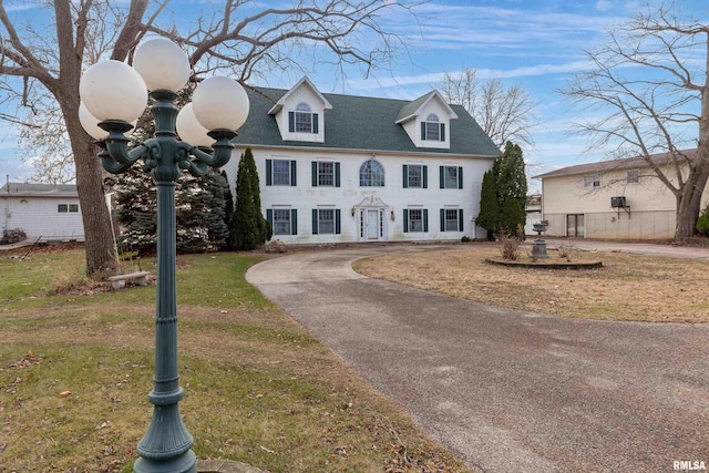 colonial inspired home with a front lawn