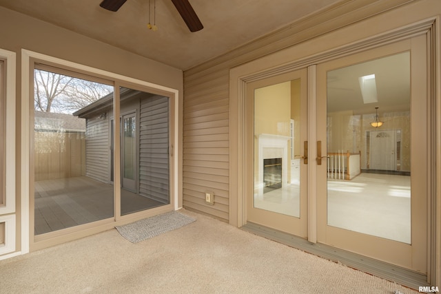 unfurnished sunroom featuring ceiling fan and french doors