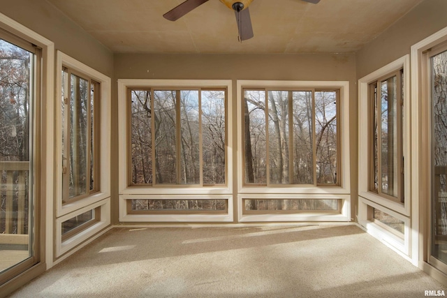 unfurnished sunroom featuring ceiling fan