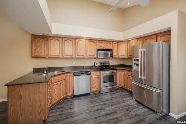 kitchen featuring ceiling fan, sink, dark hardwood / wood-style flooring, a towering ceiling, and appliances with stainless steel finishes