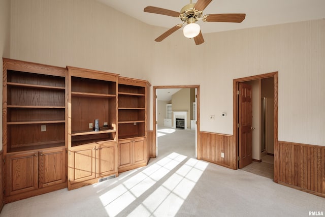 unfurnished living room with ceiling fan and light carpet