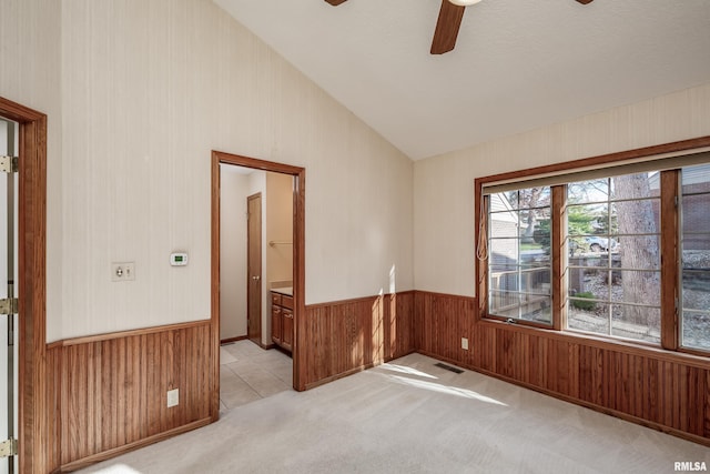 carpeted empty room featuring ceiling fan and vaulted ceiling