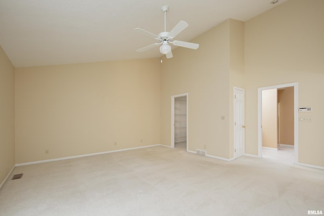 carpeted empty room with high vaulted ceiling and ceiling fan