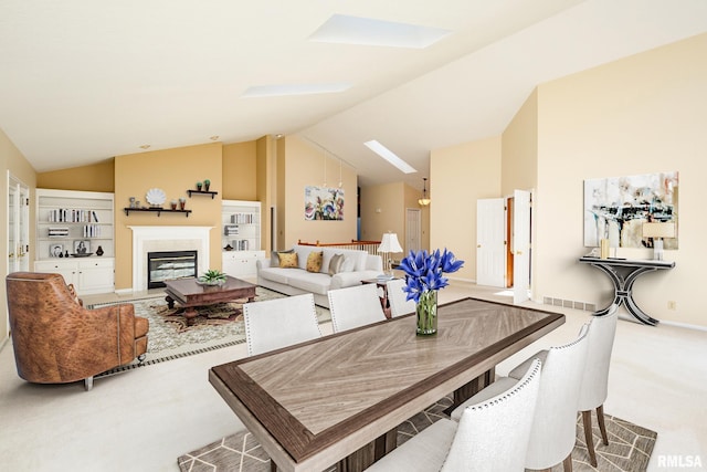 dining room with carpet flooring and lofted ceiling with skylight