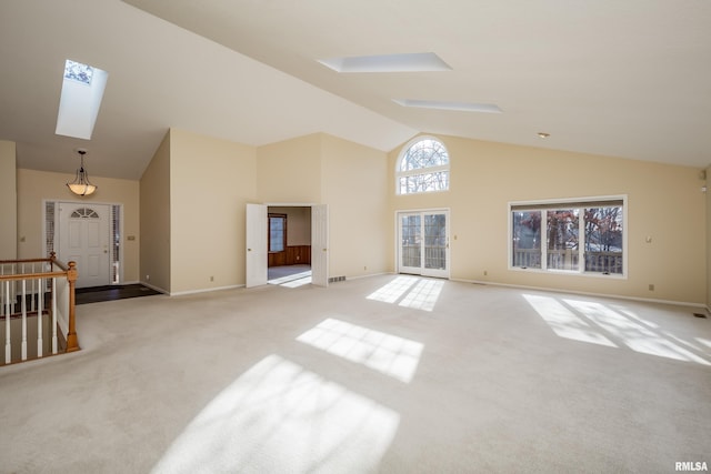 living room featuring a skylight, light carpet, and high vaulted ceiling