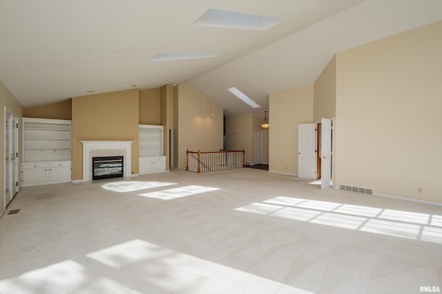 unfurnished living room featuring light carpet and lofted ceiling with skylight