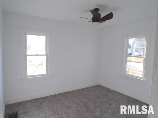 carpeted spare room featuring ceiling fan