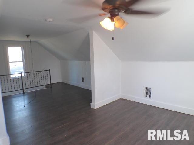 additional living space featuring dark hardwood / wood-style floors, ceiling fan, and vaulted ceiling