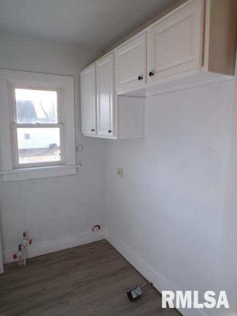 laundry room with cabinets, dark hardwood / wood-style flooring, and gas dryer hookup