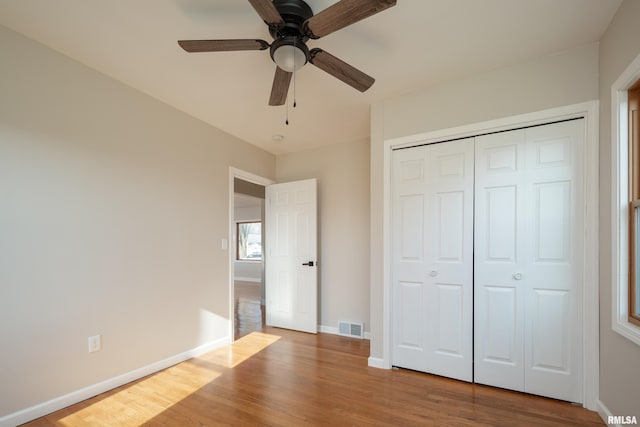 unfurnished bedroom with ceiling fan, a closet, and light hardwood / wood-style floors