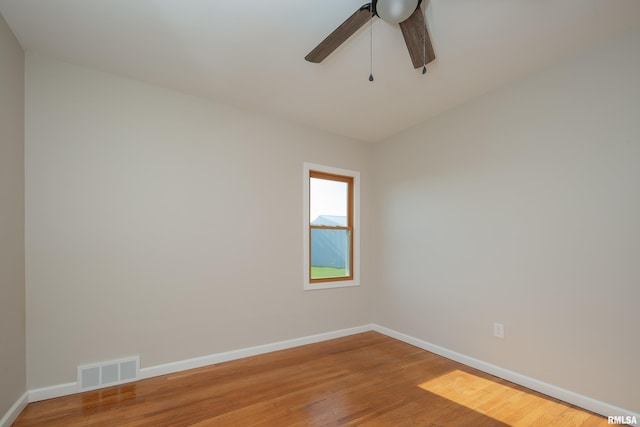 empty room with hardwood / wood-style floors and ceiling fan