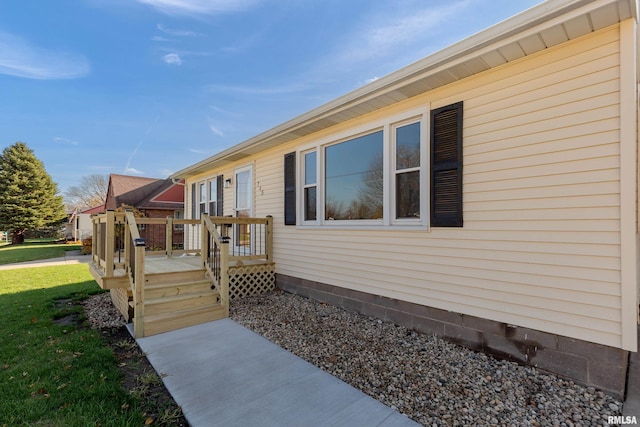 view of side of home featuring a deck and a lawn