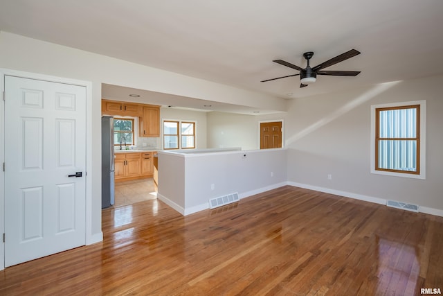 spare room with ceiling fan, light hardwood / wood-style flooring, and sink