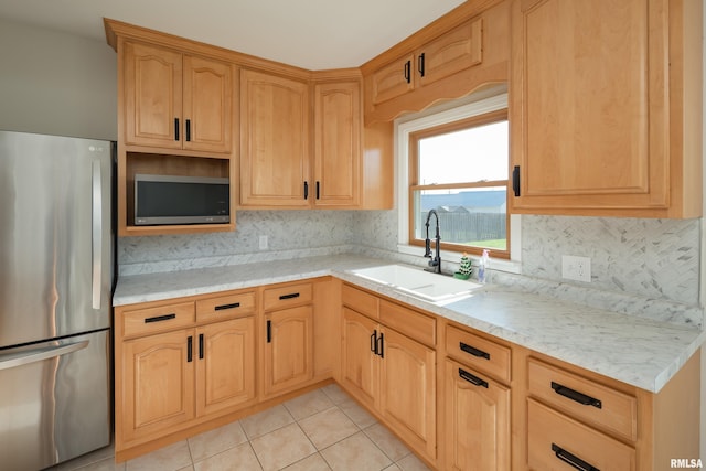 kitchen with light stone counters, light tile patterned flooring, sink, and stainless steel appliances